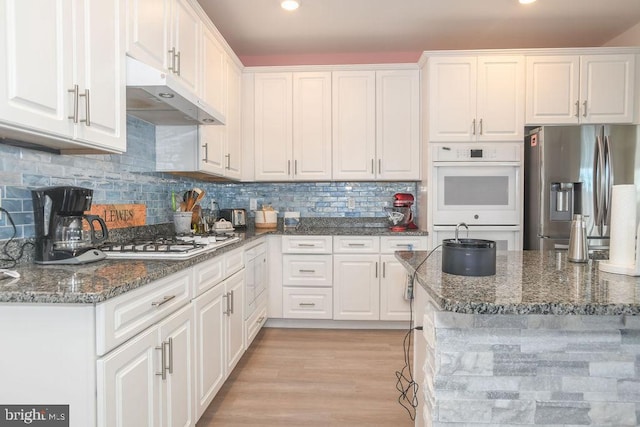 kitchen featuring white cabinets, dark stone counters, and appliances with stainless steel finishes