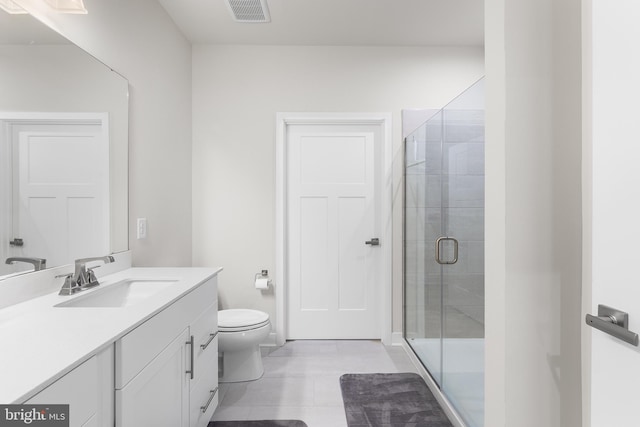 bathroom featuring vanity, walk in shower, toilet, and tile patterned flooring