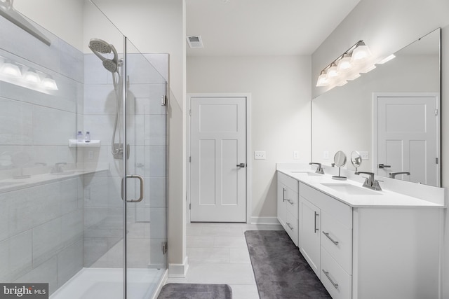 bathroom with vanity, a shower with shower door, and tile patterned floors