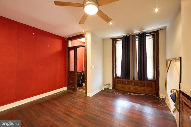 spare room with dark hardwood / wood-style floors and ceiling fan