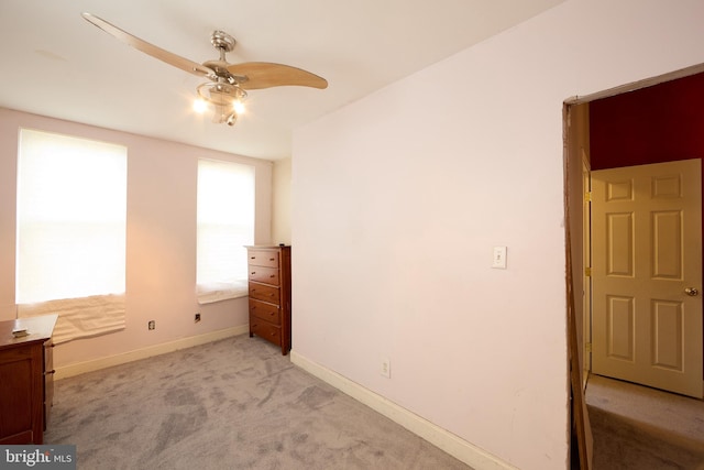 unfurnished bedroom with ceiling fan and light colored carpet