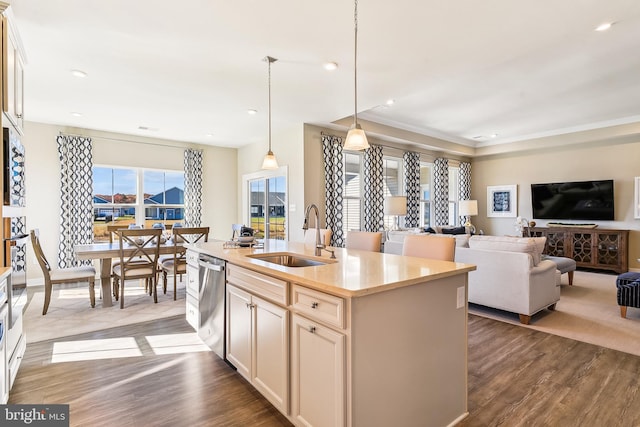 kitchen with decorative light fixtures, sink, a center island with sink, and dark hardwood / wood-style flooring