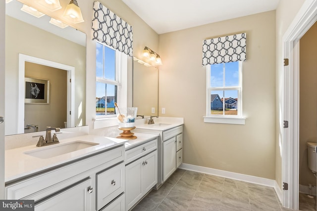 bathroom featuring a wealth of natural light, vanity, toilet, and tile patterned floors