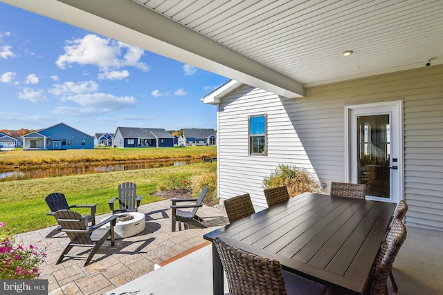 view of patio with an outdoor fire pit and a water view