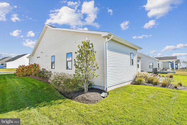 view of property exterior featuring central air condition unit and a lawn