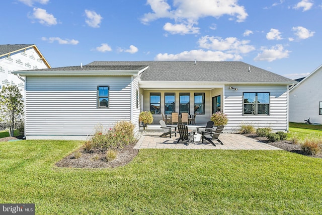 rear view of house featuring a yard and a patio area