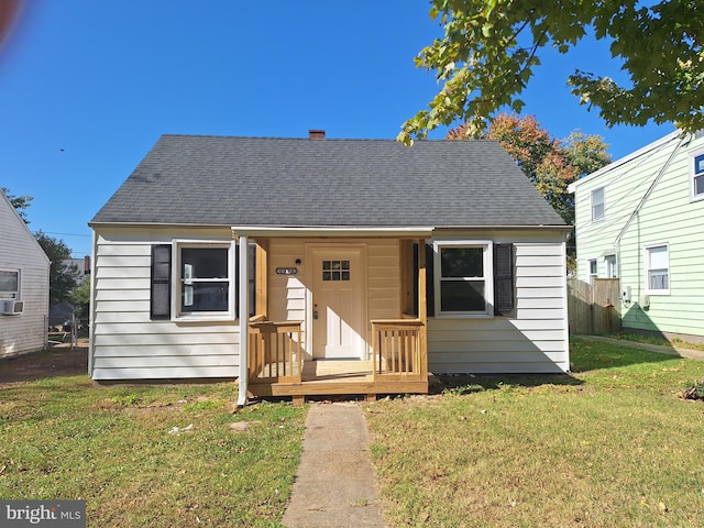 bungalow-style house with cooling unit and a front lawn