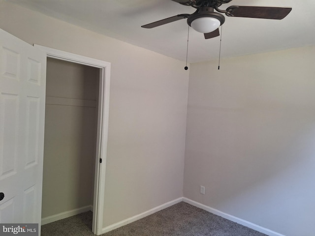 unfurnished bedroom with dark colored carpet, a closet, and ceiling fan