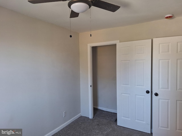 unfurnished bedroom with a closet, ceiling fan, and dark carpet