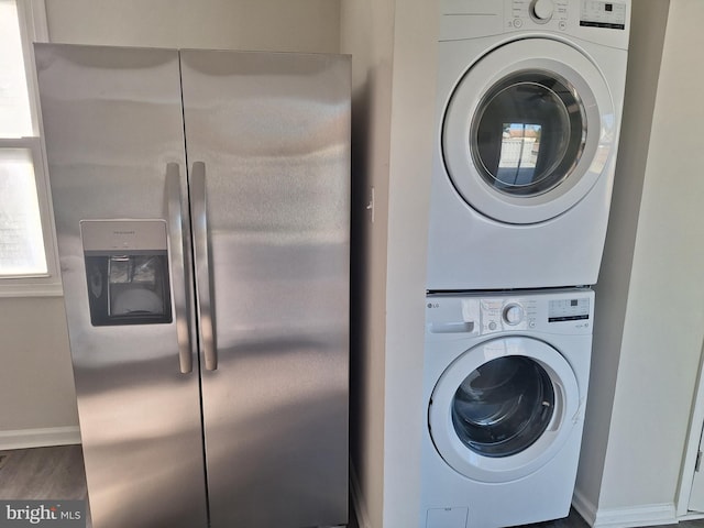 clothes washing area with stacked washer and dryer and hardwood / wood-style floors