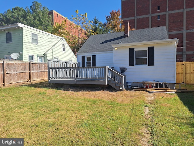 back of property with a wooden deck and a lawn