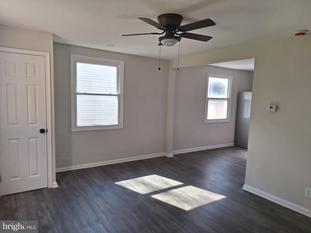 spare room with dark hardwood / wood-style floors and ceiling fan