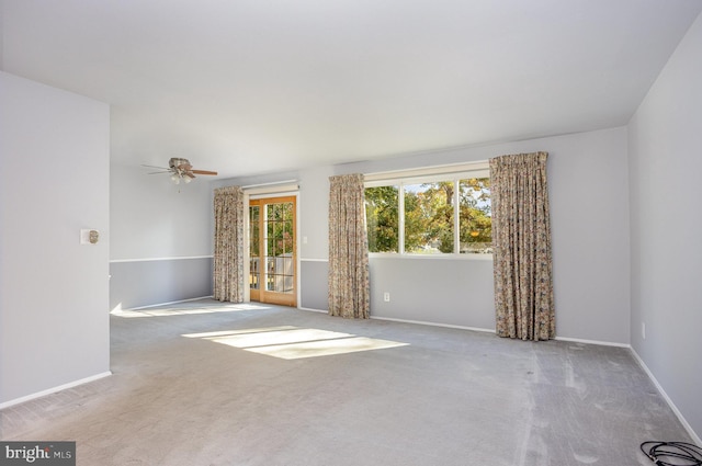 carpeted spare room featuring ceiling fan