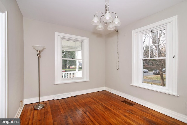 unfurnished room featuring hardwood / wood-style floors and a notable chandelier