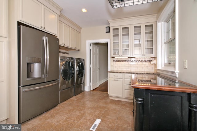 laundry room with washing machine and clothes dryer and light tile patterned floors