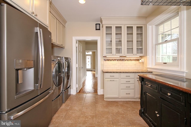 laundry room featuring washer and clothes dryer, cabinets, and light hardwood / wood-style flooring