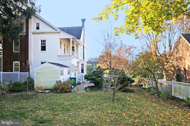 view of side of home featuring a lawn and a balcony