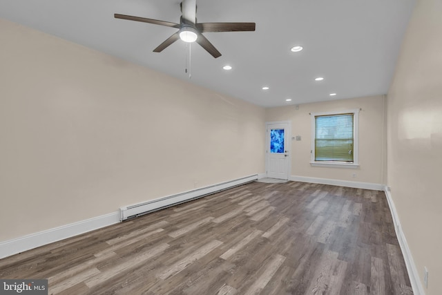 empty room featuring light wood-type flooring, ceiling fan, and a baseboard heating unit