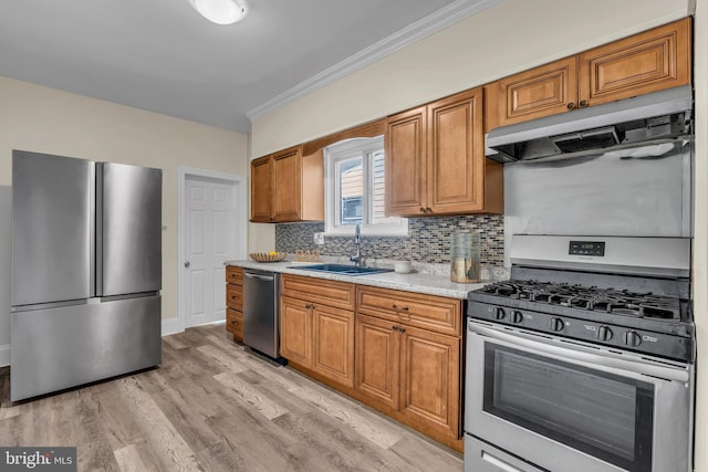 kitchen with sink, backsplash, light hardwood / wood-style floors, appliances with stainless steel finishes, and ornamental molding