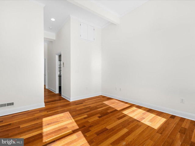 empty room featuring recessed lighting, baseboards, visible vents, wood finished floors, and beam ceiling