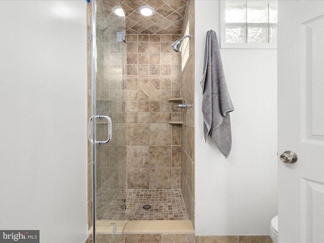 bathroom with an enclosed shower and toilet