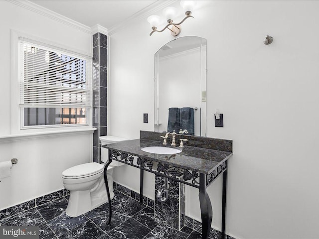 bathroom featuring crown molding, toilet, and sink