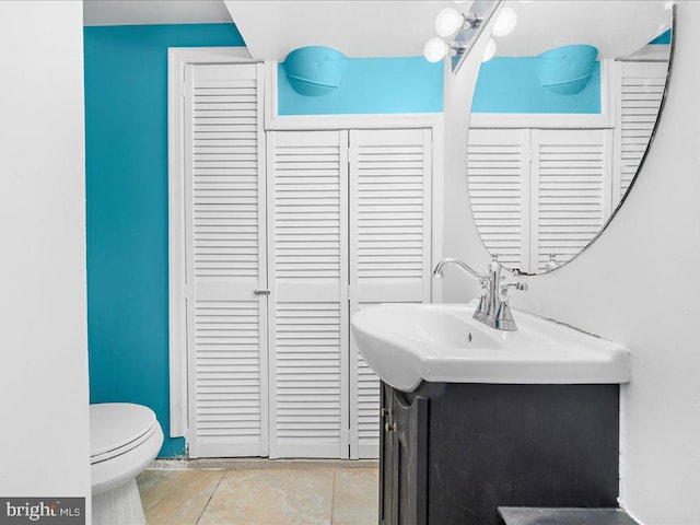 bathroom with vanity, toilet, and tile patterned flooring
