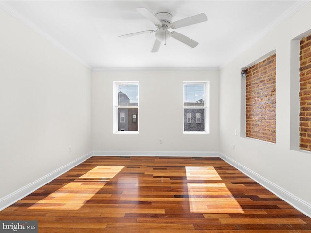 empty room featuring baseboards, ornamental molding, ceiling fan, and wood finished floors