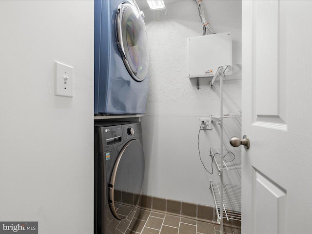 clothes washing area with stacked washer / dryer and laundry area