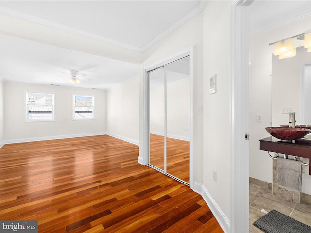 interior space featuring ceiling fan, sink, ornamental molding, and hardwood / wood-style flooring