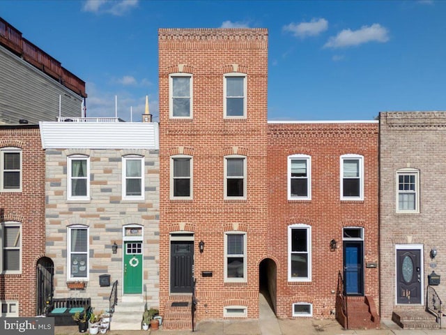 townhome / multi-family property with entry steps and brick siding