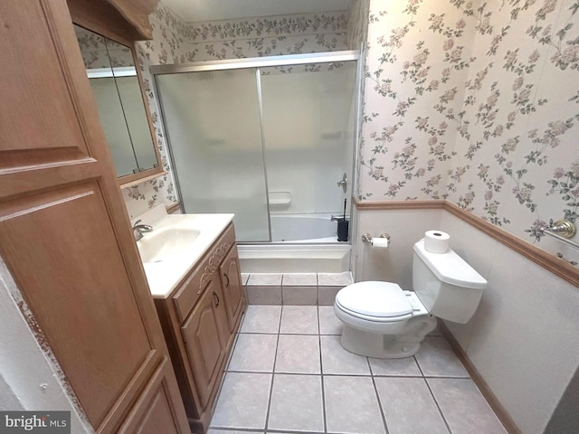 full bathroom featuring tile patterned floors, shower / bath combination with glass door, vanity, and toilet