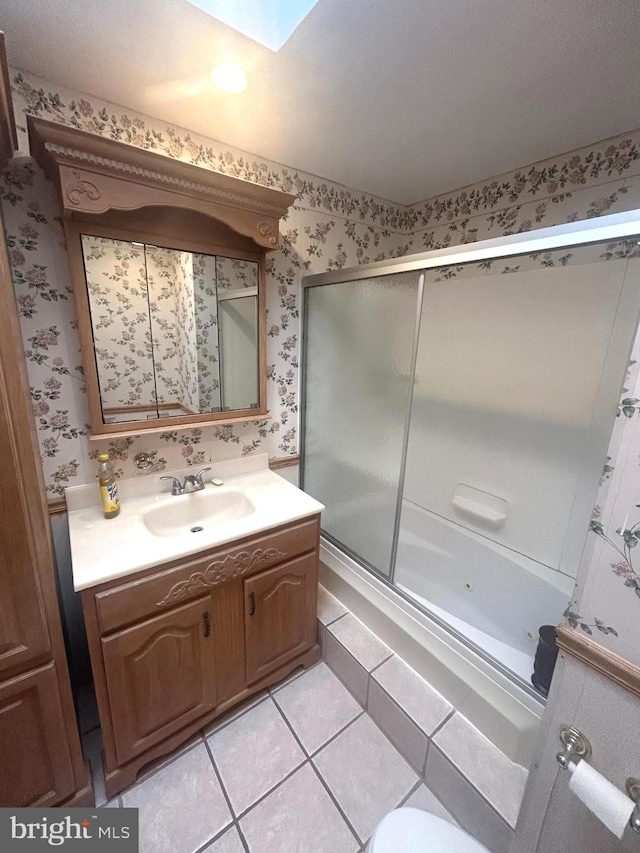 bathroom featuring tile patterned floors, vanity, shower / bath combination with glass door, and a skylight