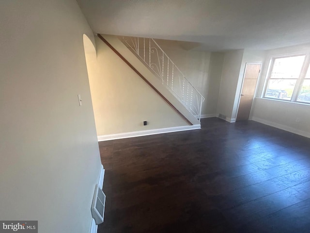 unfurnished room with dark wood-type flooring