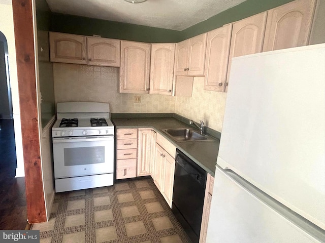 kitchen featuring light brown cabinetry, sink, and white appliances