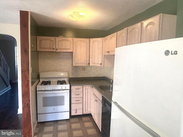 kitchen with light brown cabinets, white appliances, a textured ceiling, and sink