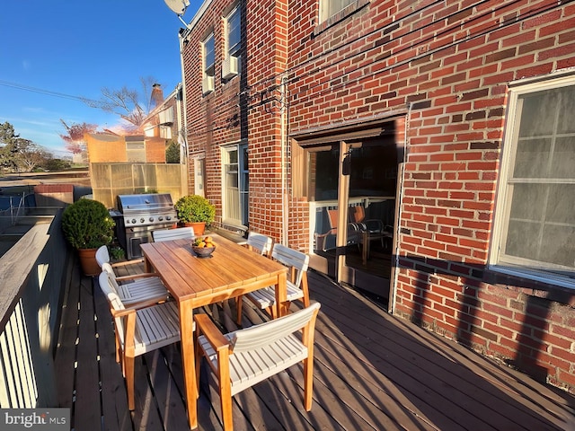 deck featuring a grill and cooling unit