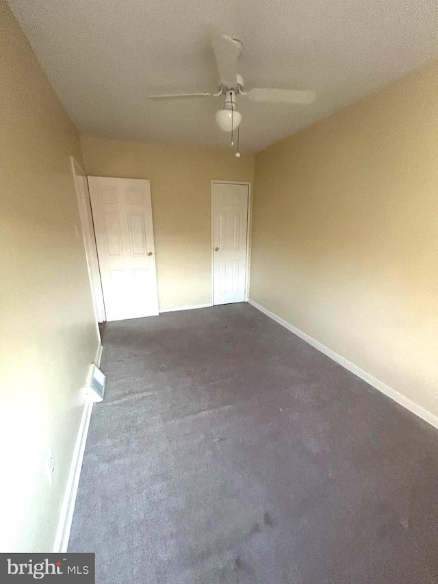 carpeted spare room with ceiling fan