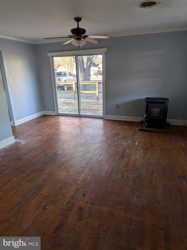 interior space with ceiling fan, a wood stove, dark wood-type flooring, and ornamental molding