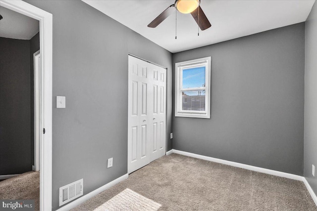 unfurnished bedroom with carpet floors, a closet, and ceiling fan