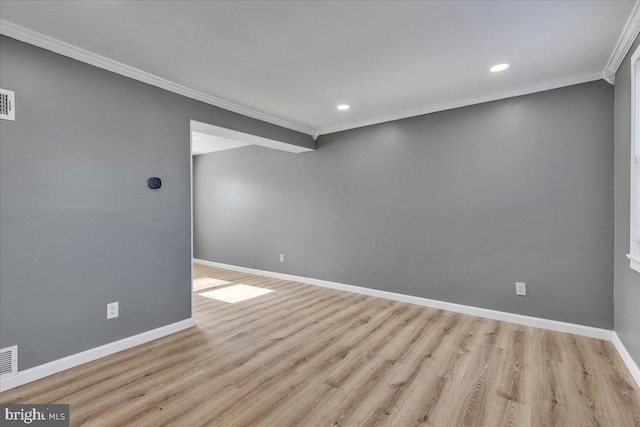 empty room featuring ornamental molding and light wood-type flooring