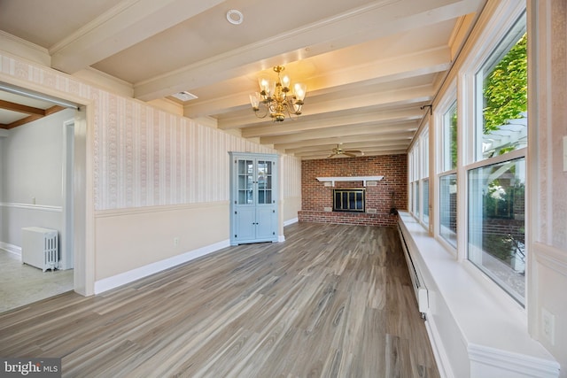 interior space featuring radiator heating unit, hardwood / wood-style flooring, beamed ceiling, and a brick fireplace