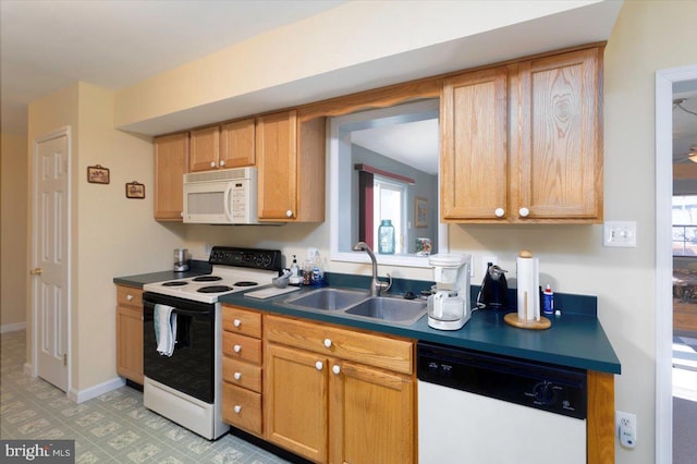 kitchen featuring white appliances, sink, and plenty of natural light