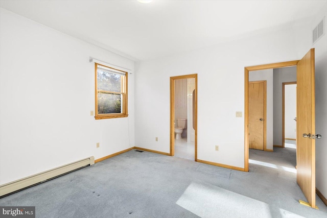 unfurnished bedroom featuring ensuite bathroom, a baseboard heating unit, and light colored carpet