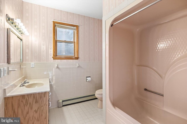 full bathroom featuring toilet, tile walls, baseboard heating, vanity, and tile patterned flooring