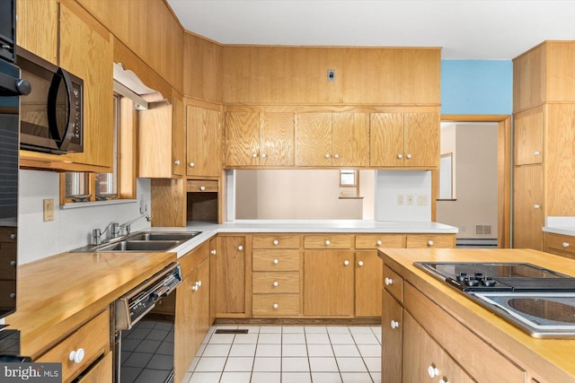 kitchen featuring light tile patterned flooring, black appliances, and sink