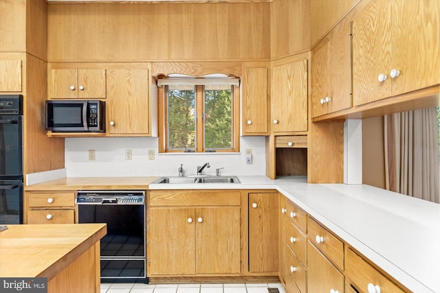 kitchen featuring sink, black appliances, and light tile patterned flooring