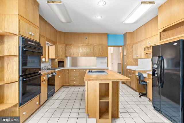 kitchen featuring wood counters, black appliances, sink, and light tile patterned floors