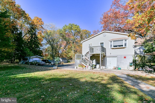 view of front of property with a wooden deck, a front yard, and a garage