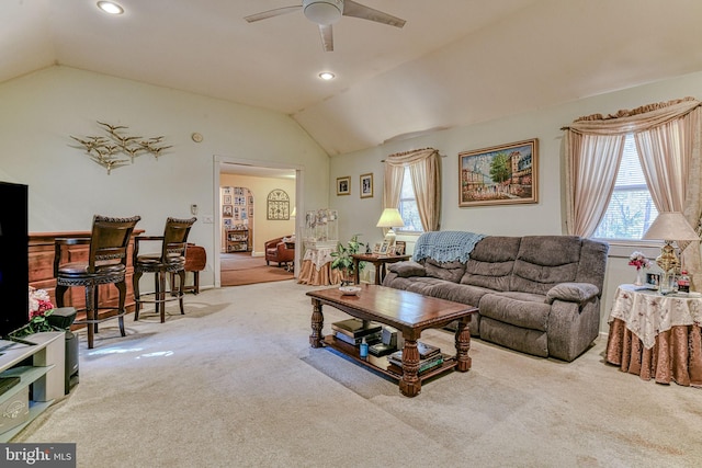 living room featuring ceiling fan, light colored carpet, and vaulted ceiling